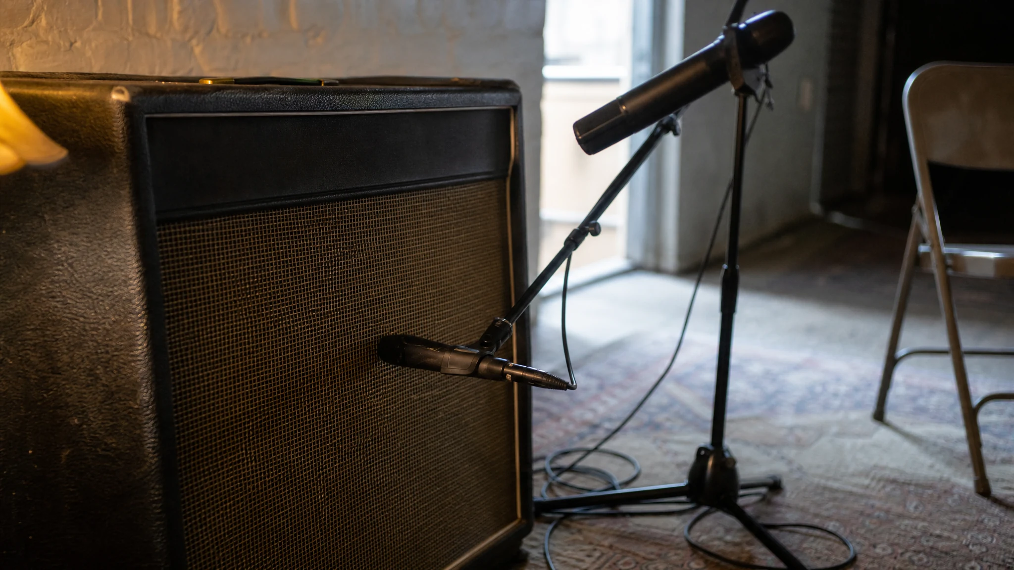 A guitar speaker cabinet miked twice: a dynamic on the grille cloth and a second microphone about a metre behind it
